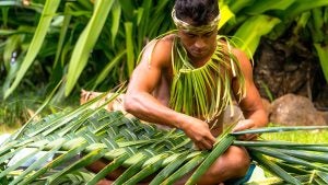 a man weaving a basket