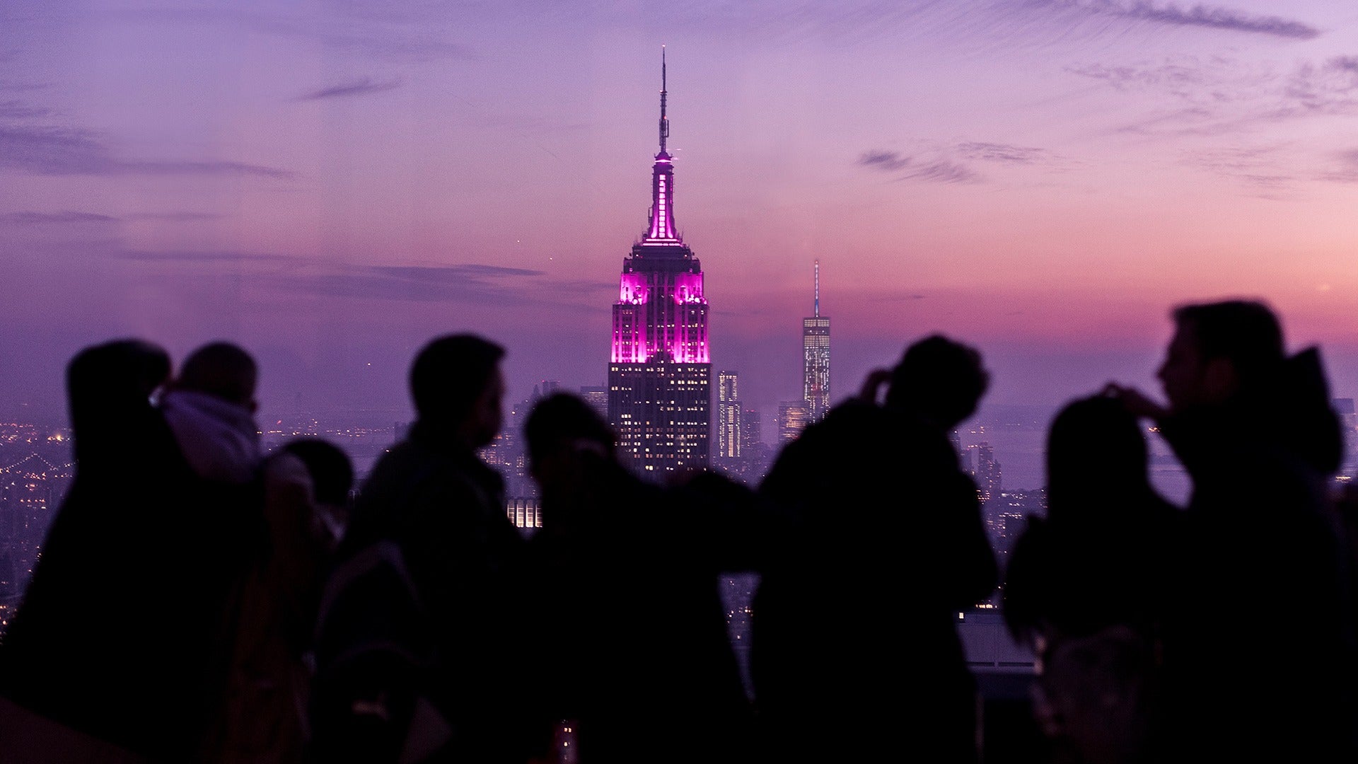 people at an observation deck with a view of the empire state building