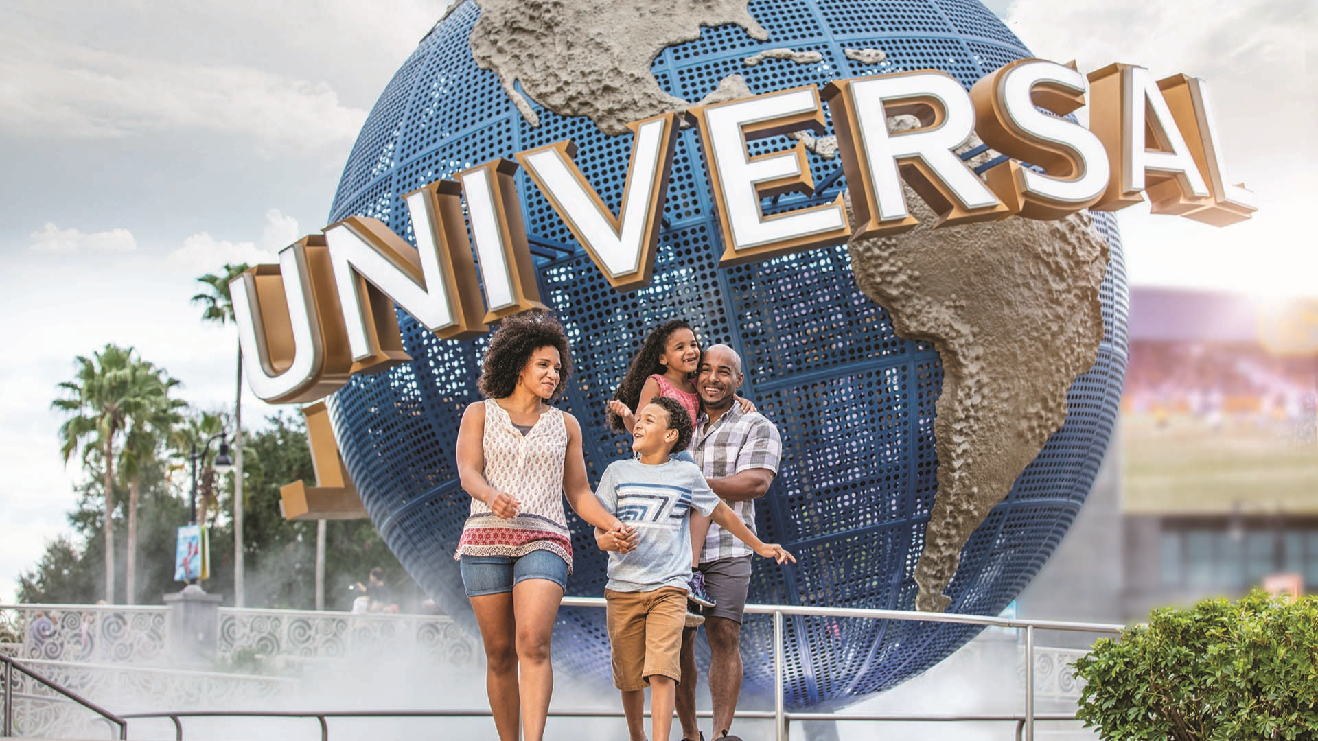 a family walking in front of the universal orlando signage
