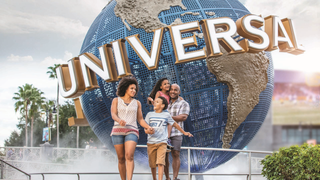 a family walking in front of the universal orlando signage