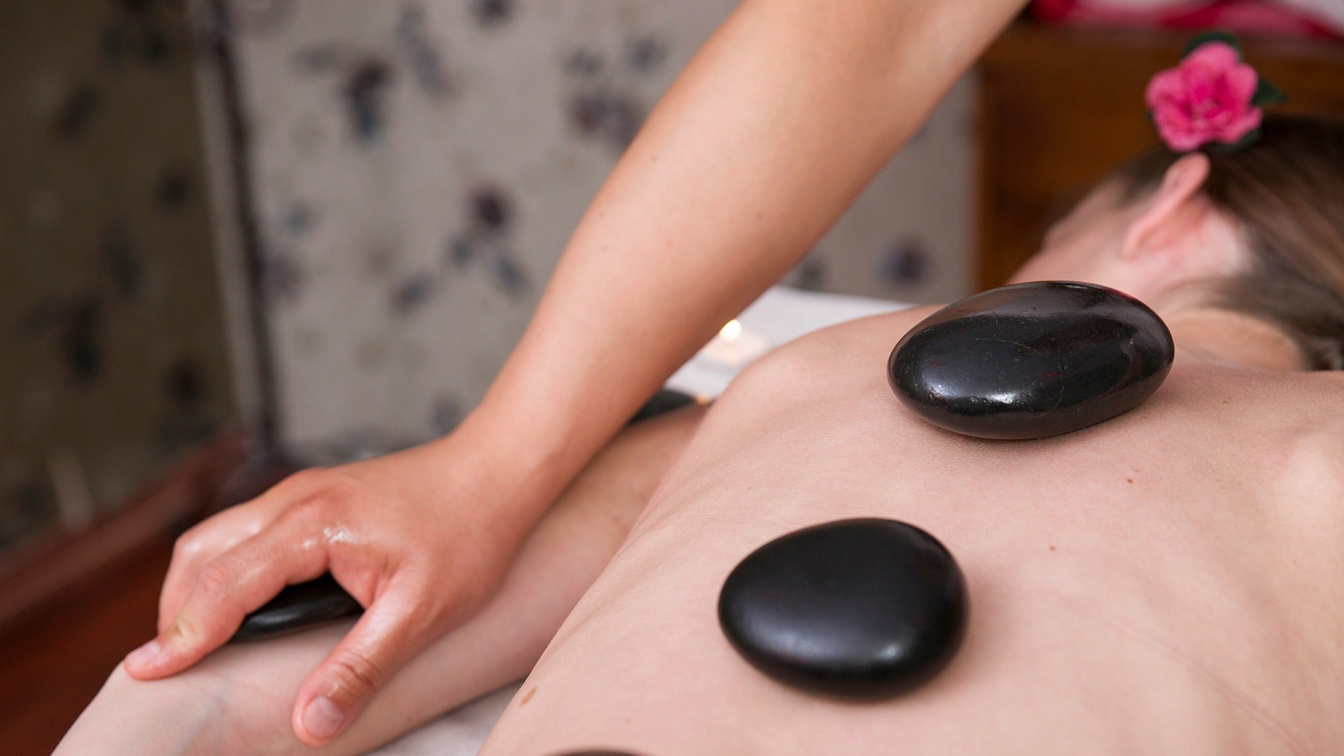 a lady getting massaged with hot stones on her back
