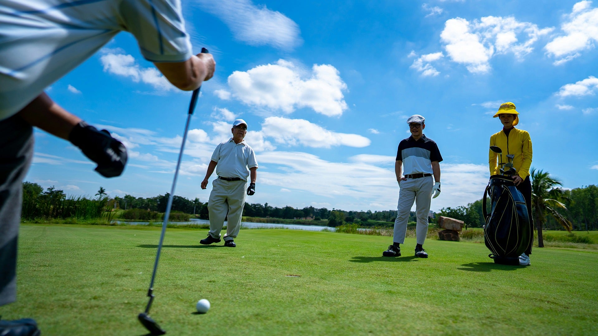men teeing off in a golf course