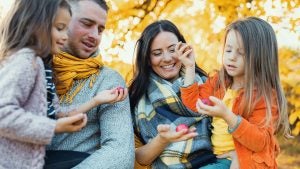 family having fun during fall wearing scarves