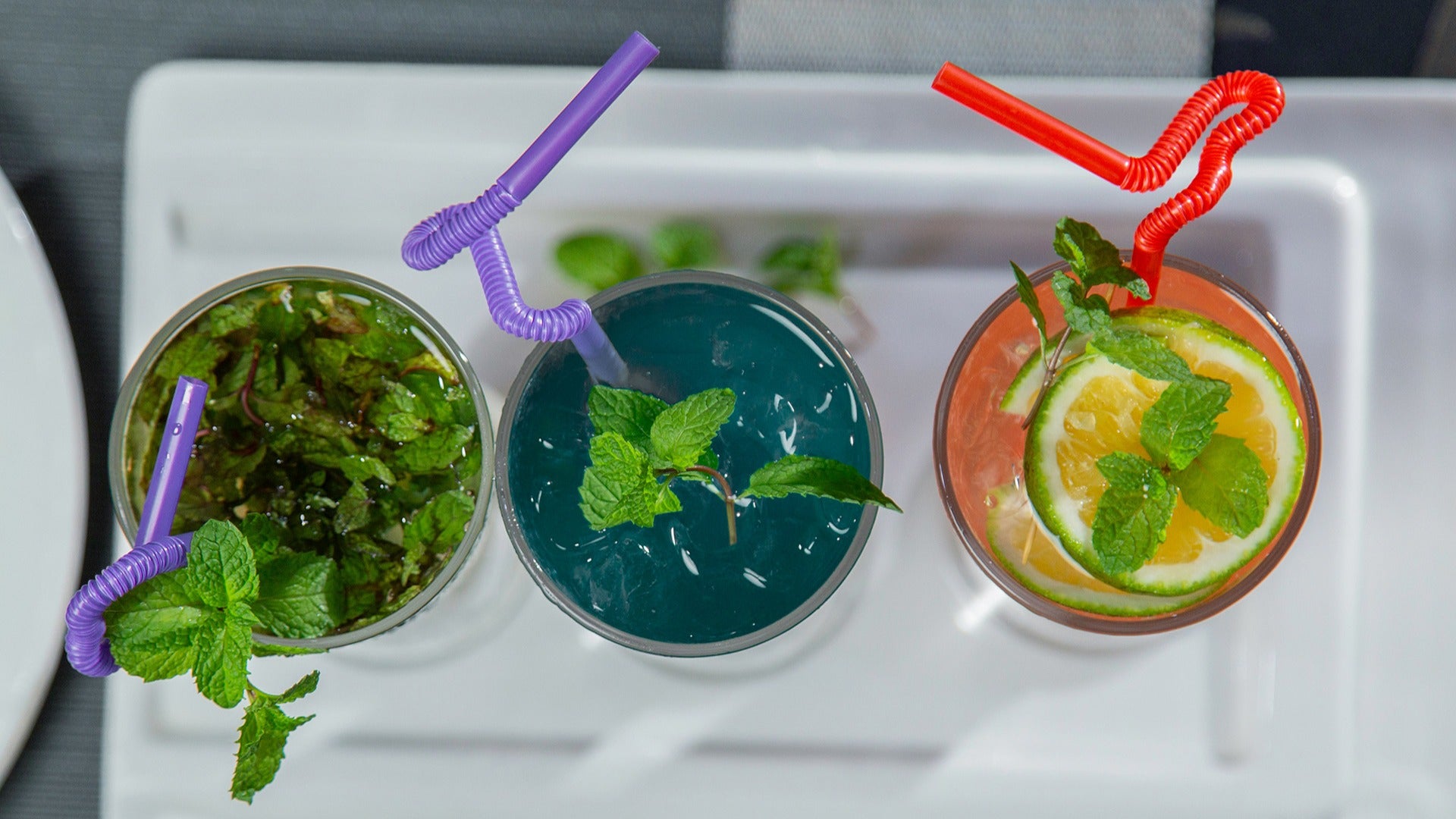 different colored drinks with different garnishes and straws