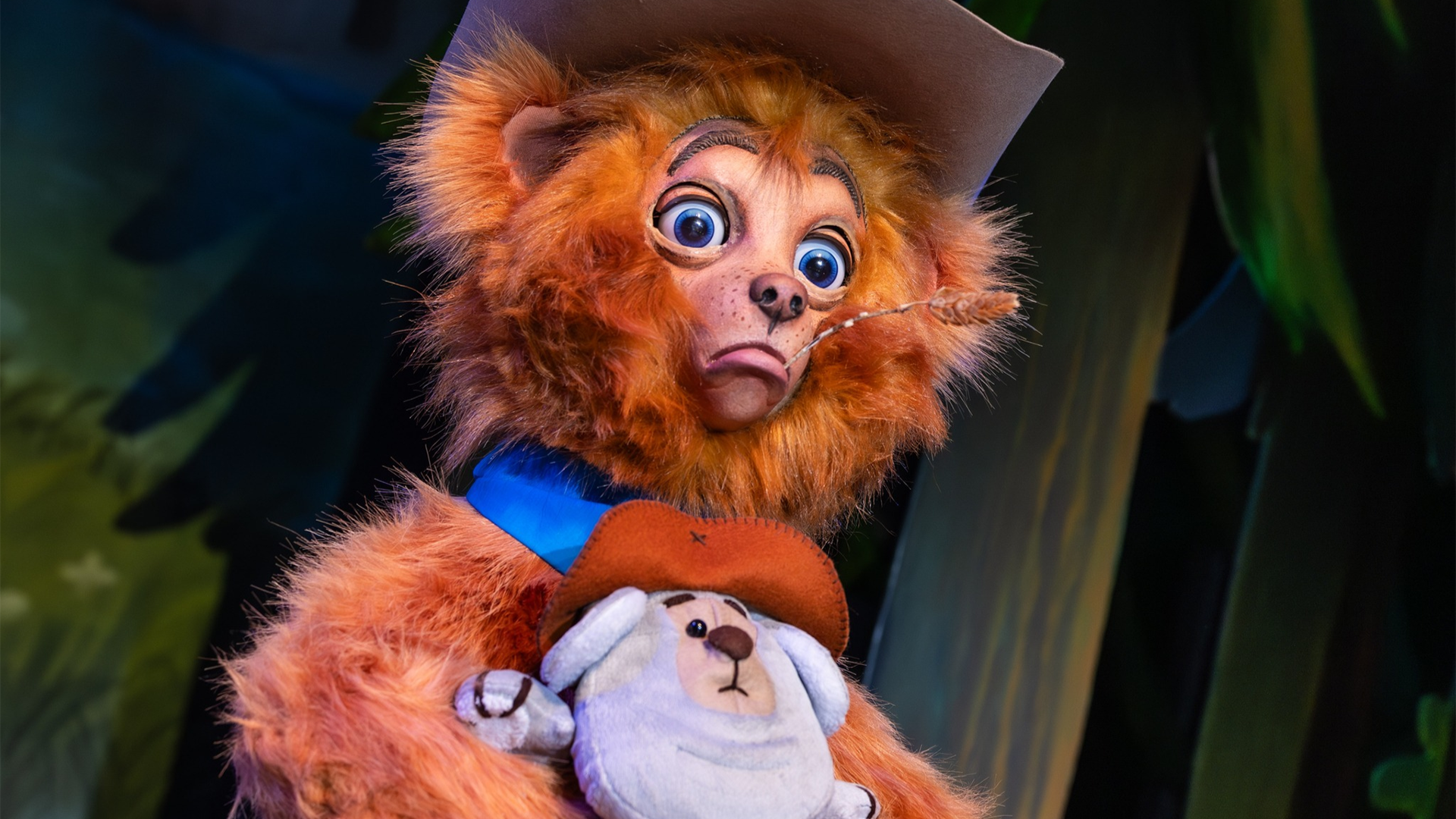 a bear with a cowboy hat holding a bear plushie