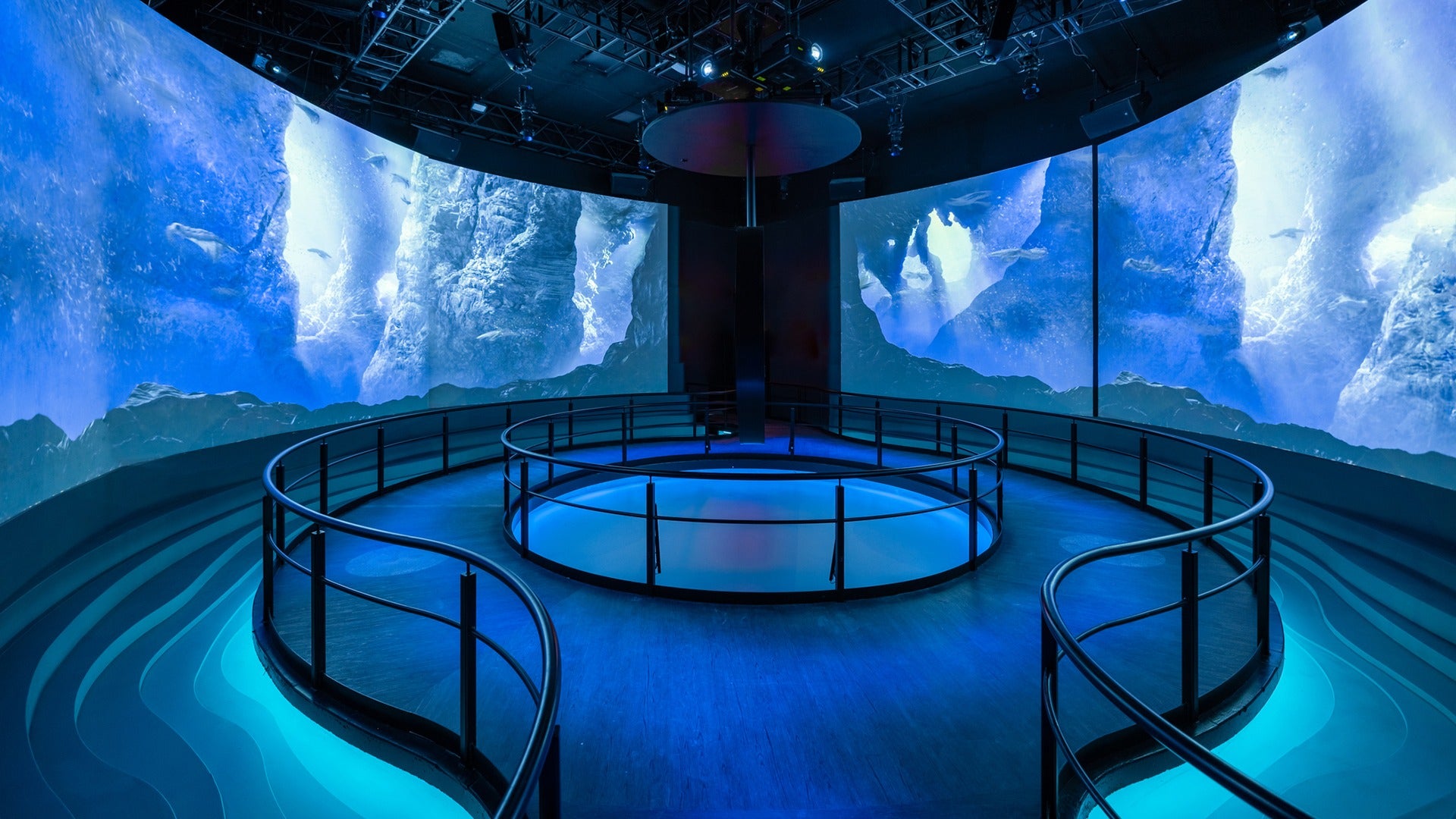 a circular room surrounded by blue LED walls with a stage in the middle