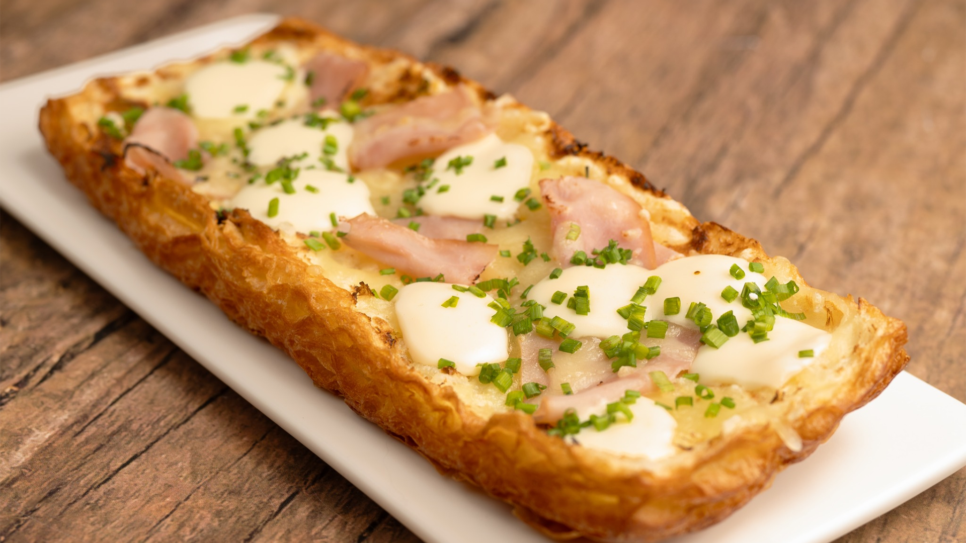 Ham and Gruyere Tart: crispy croissant dough topped with ham and gruyere served with chips