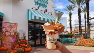 over the top milkshake dessert with a variety of toppings and the shop at the back