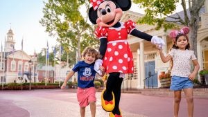minnie mouse with two kids strolling around liberty square at disney world