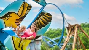 a mother and child on an amusement park ride suspended above the air