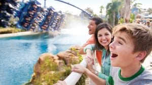 The Manta coaster gliding over a splashdown water feature, spraying mist into the air beneath the track