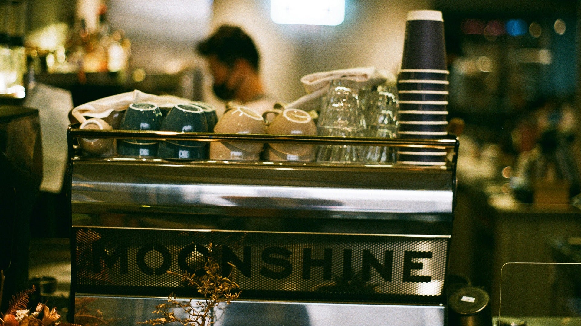 a moonshine machine with barista at the back