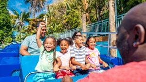 a group of kids with an adult riding an amusement park ride