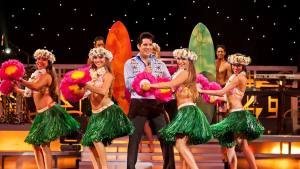 Hula dancers and an Elvis impersonator on stage at Rock-a-Hula in Honolulu, Hawaii, USA