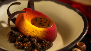 a red and yellow mouse with chocolate sides served on a plate
