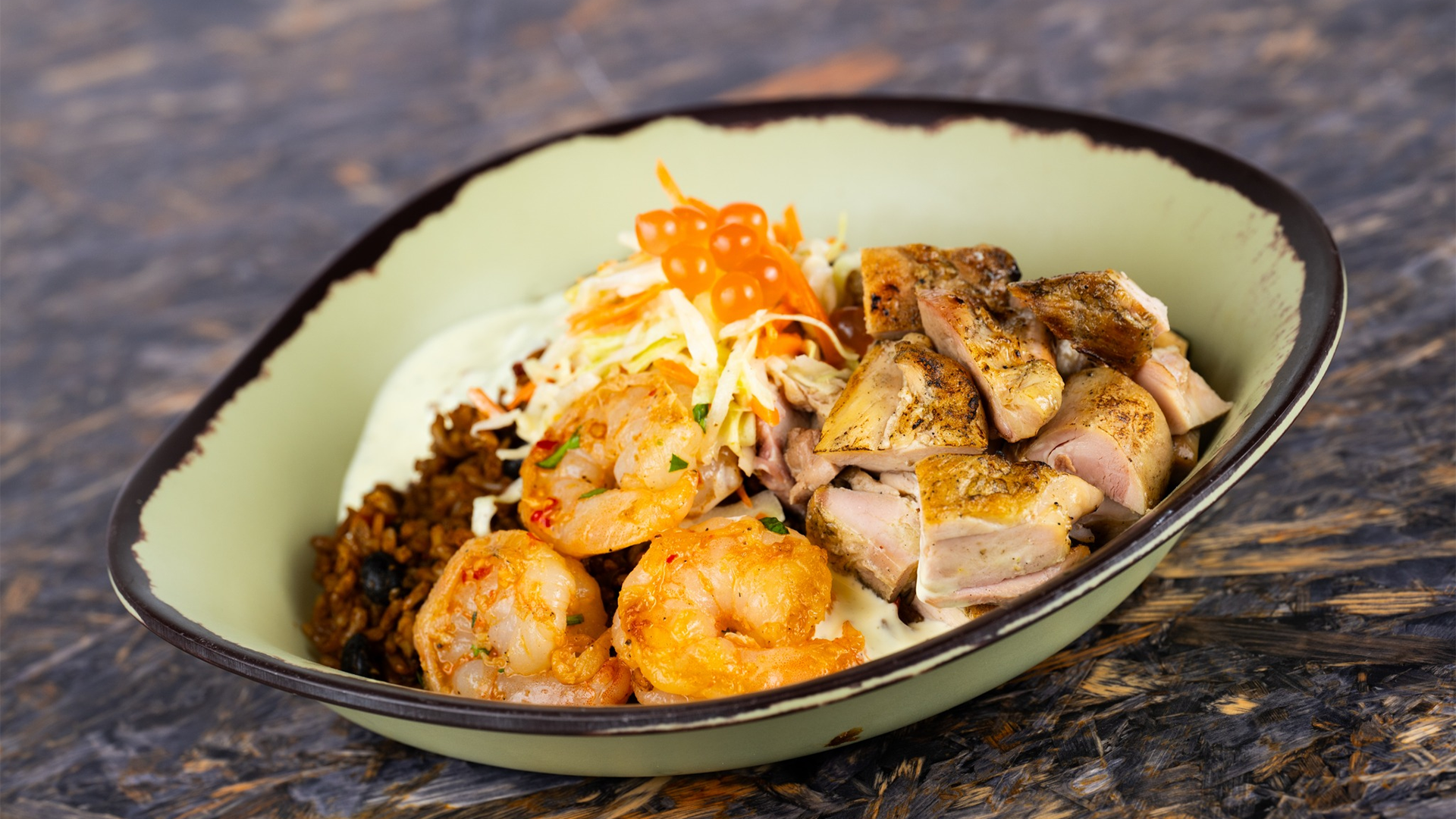 a mixed bowl of meat and seafood with egg and rice