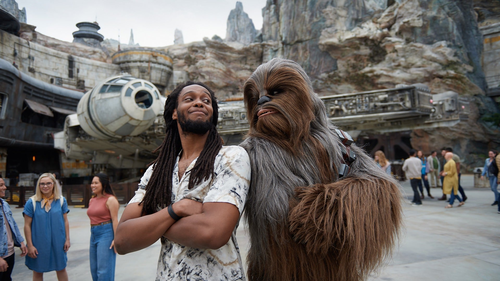 a man posing with chewbacca in a star wars galaxy edge