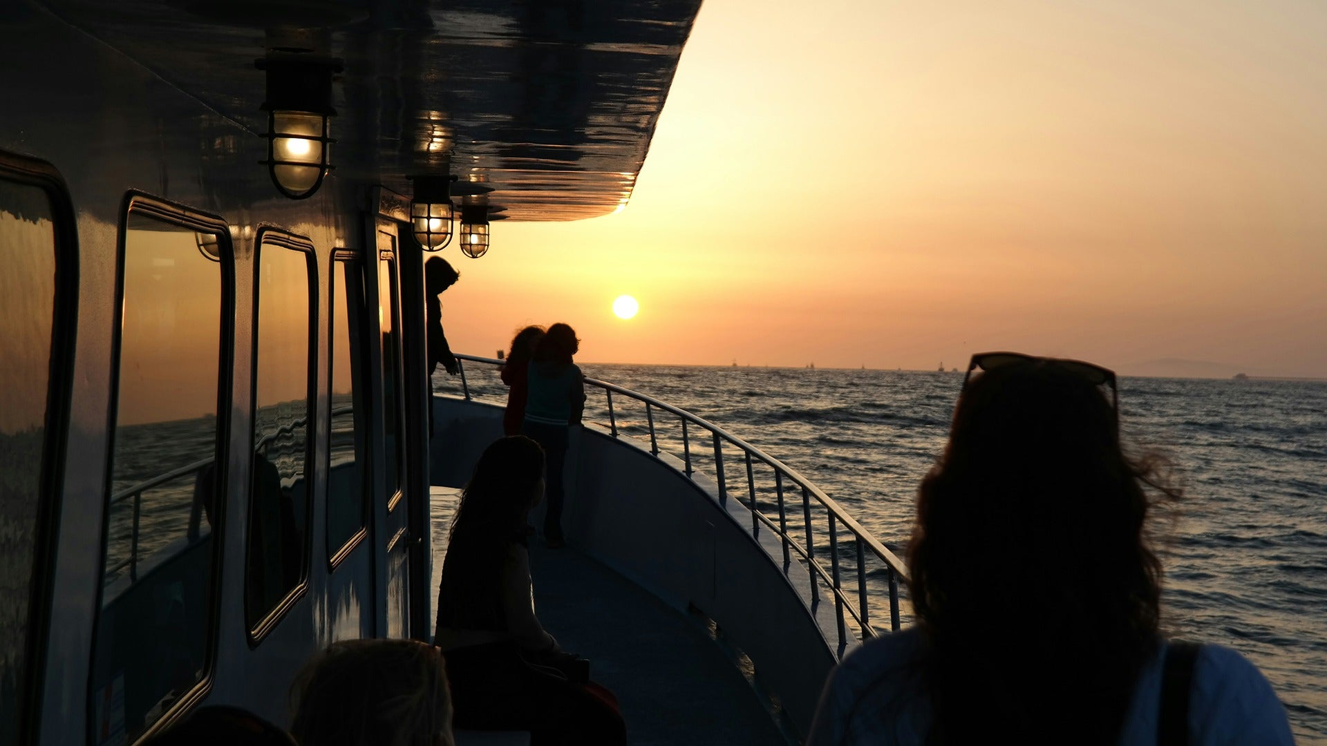 people aboard a cruise ship looking at the sunset