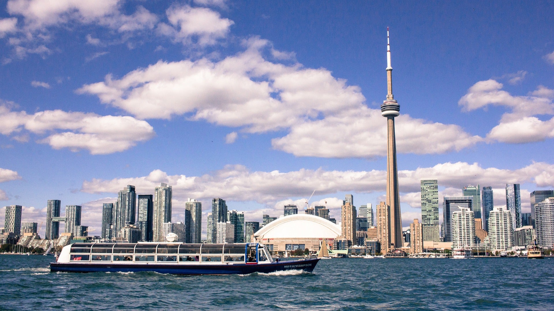 a boat cruise on the harbour passing by toronto's iconic cn tower