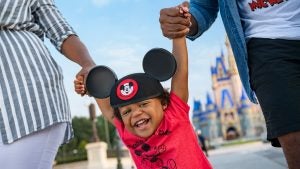 parents holding their child with a view of magic kingdom park at the back