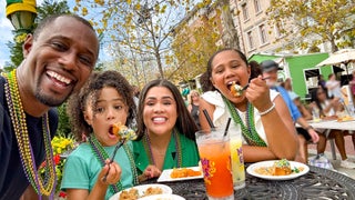 Family eating at a table taking a selfie in Mardi Gras beads