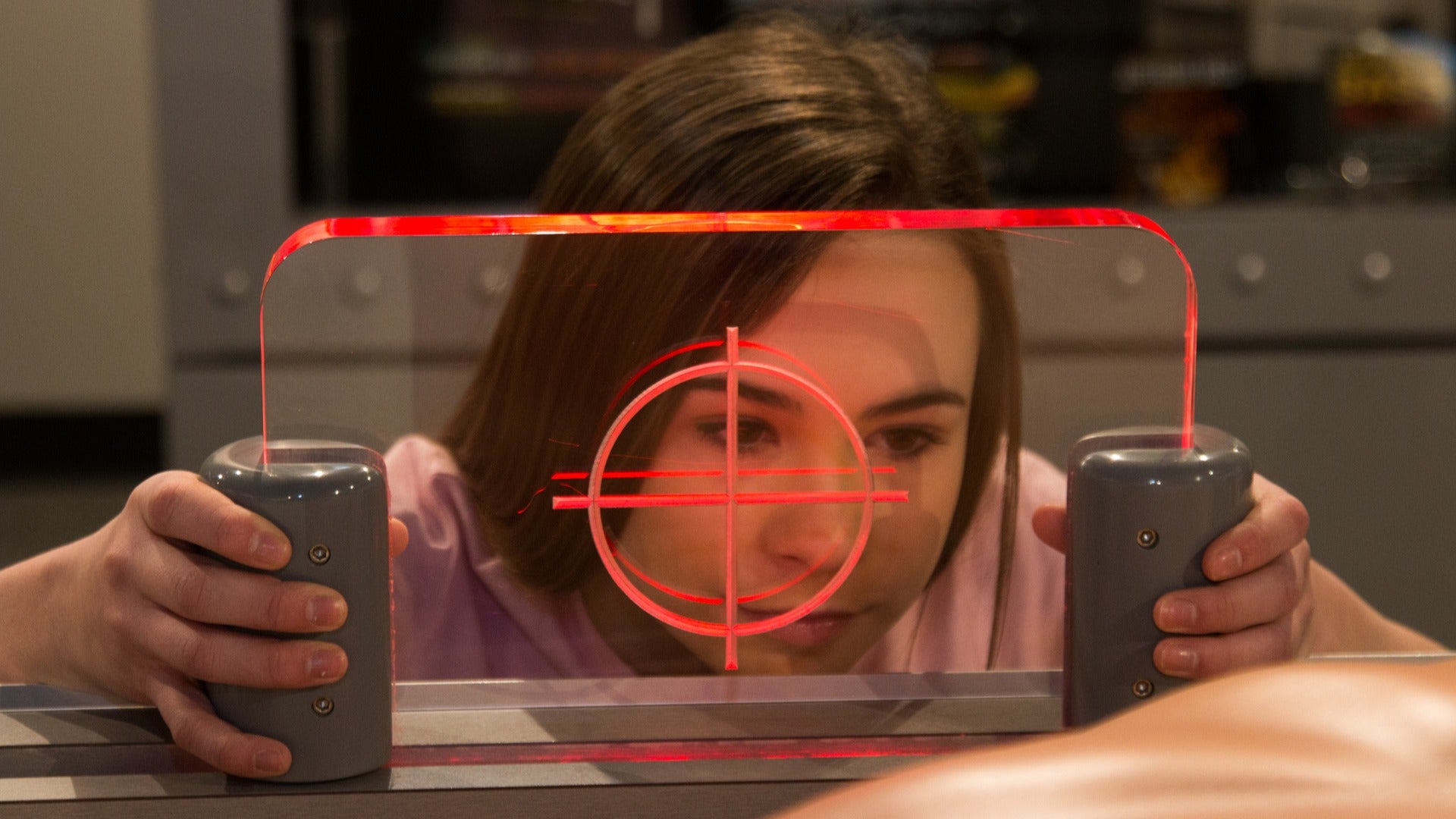 a girl playing and solving crime with a laser looking through glass