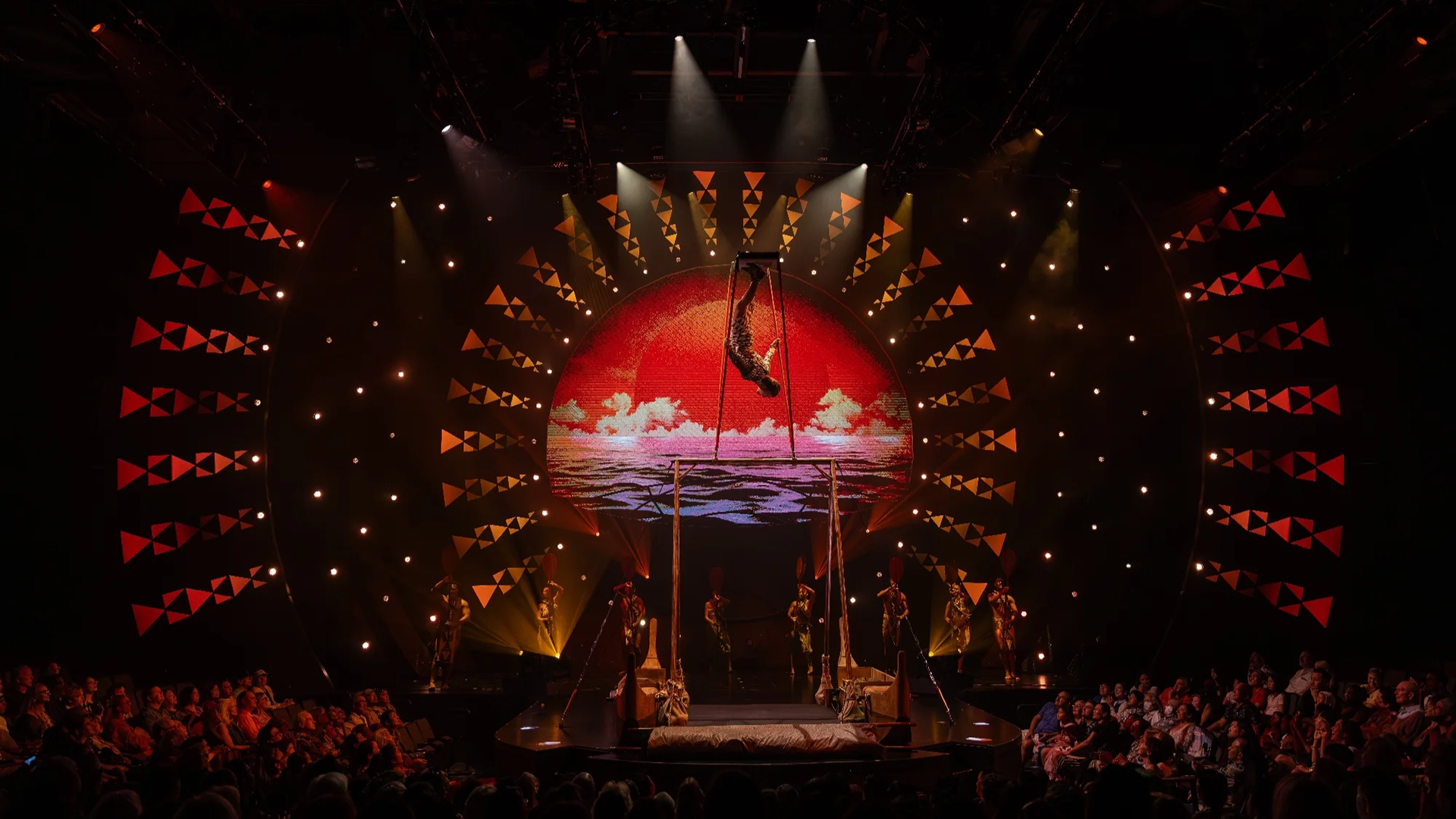 a performer on stage doing stunts and hanging off the ceiling