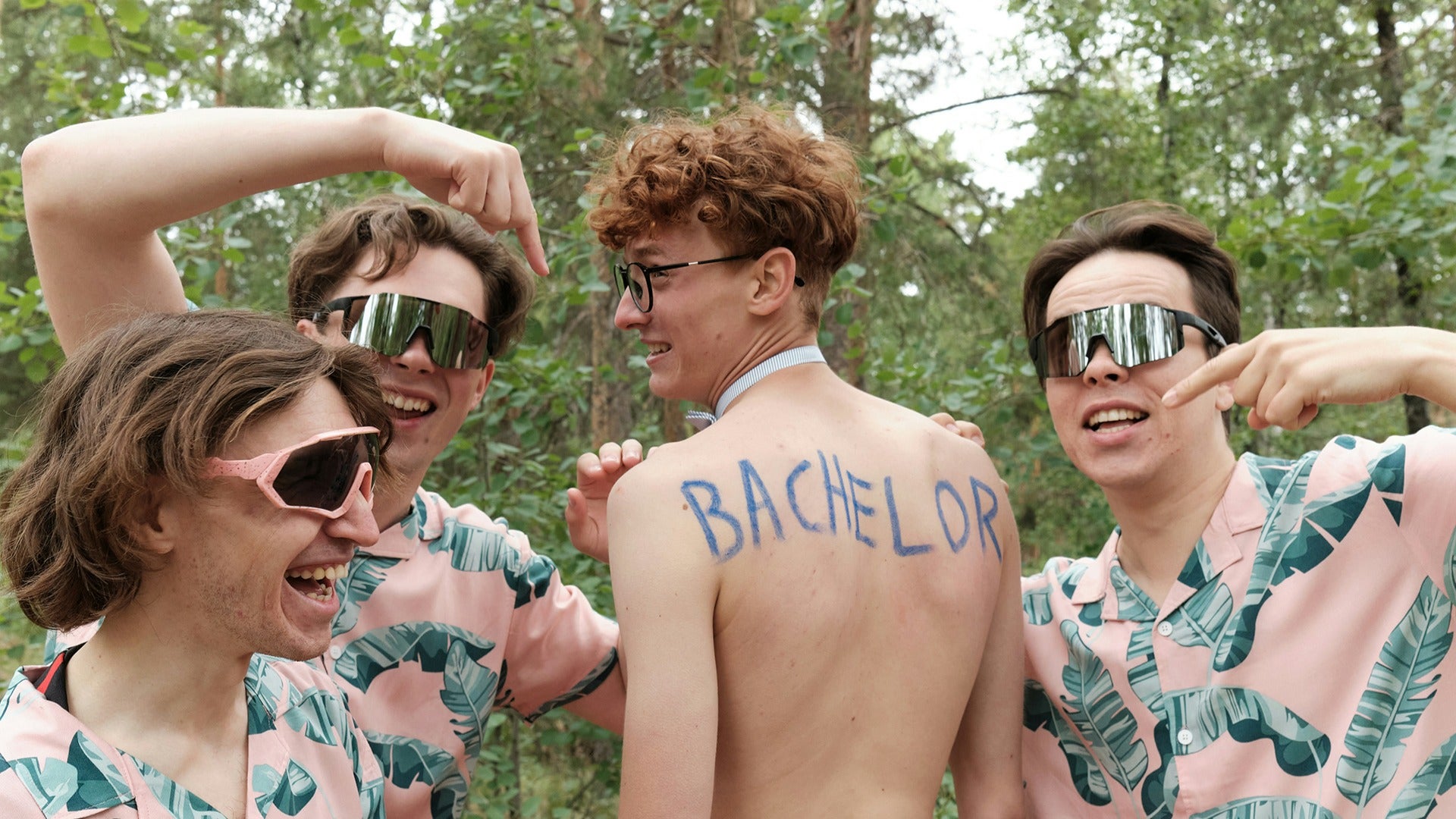 a group pf boys wearing matching shirts and shades in a bachelor party
