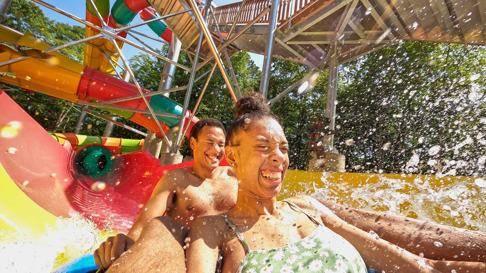 two people happily going down a water slide