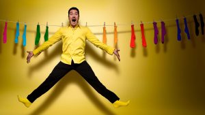 a man hanging on a clothesline along with socks