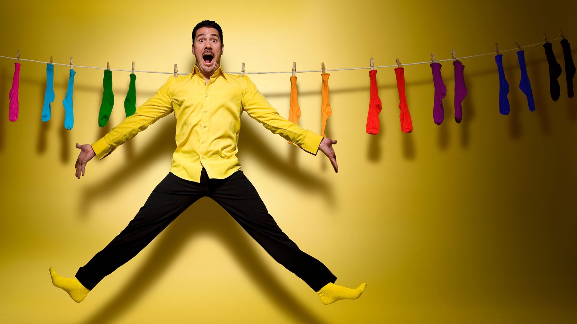 a man hanging on a clothesline along with socks