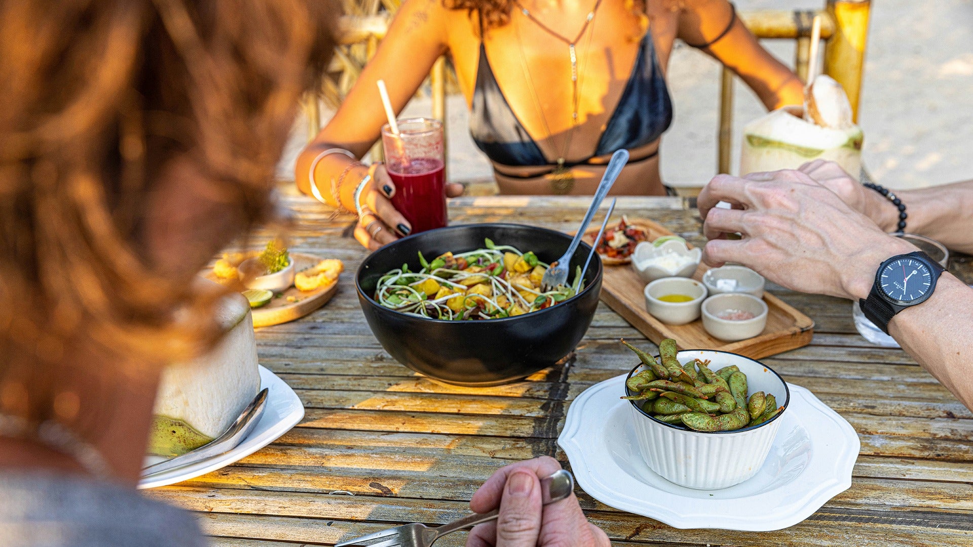 people eating at the beach an assortment of food