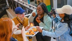 a group having a food tasting with a photographer and someone else taking phone photos