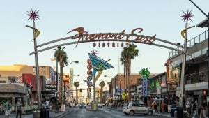 a street lined with shops and restaurants with people walking around
