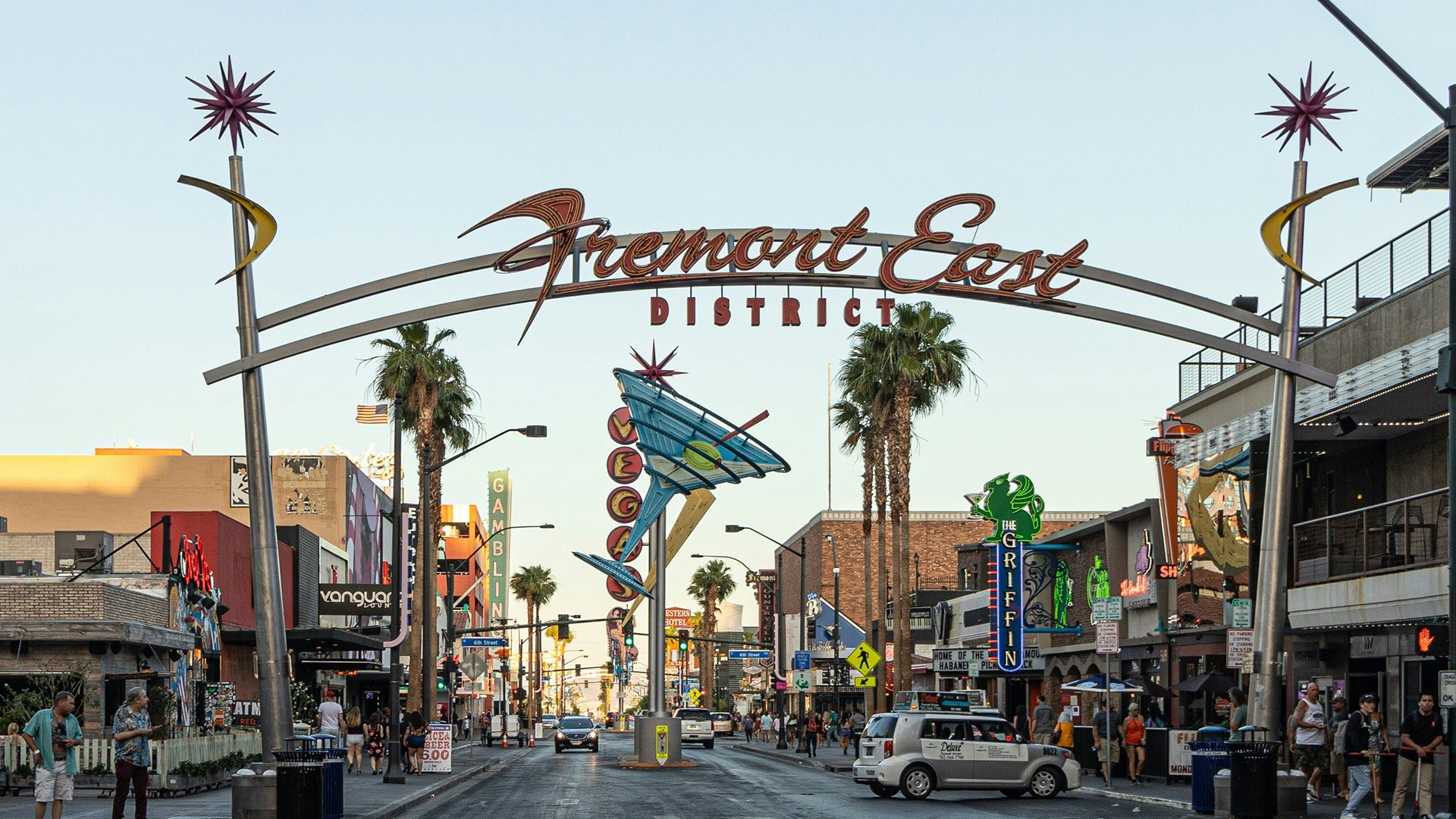 a street lined with shops and restaurants with people walking around