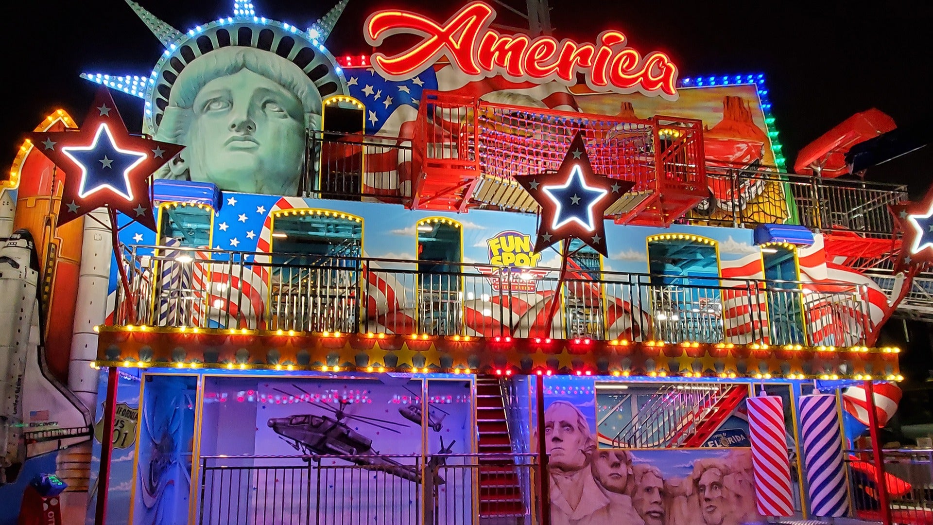 an amusement park attraction with various posters and neon lights