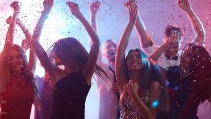 a group of people partying and dancing with confetti