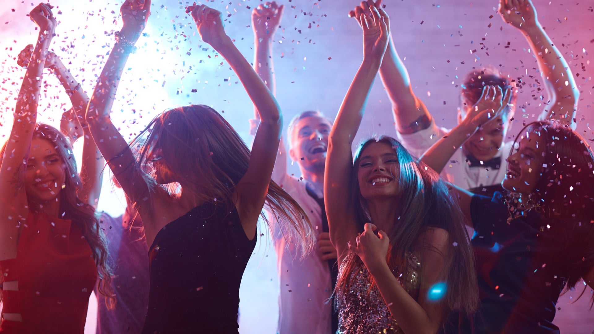a group of people partying and dancing with confetti