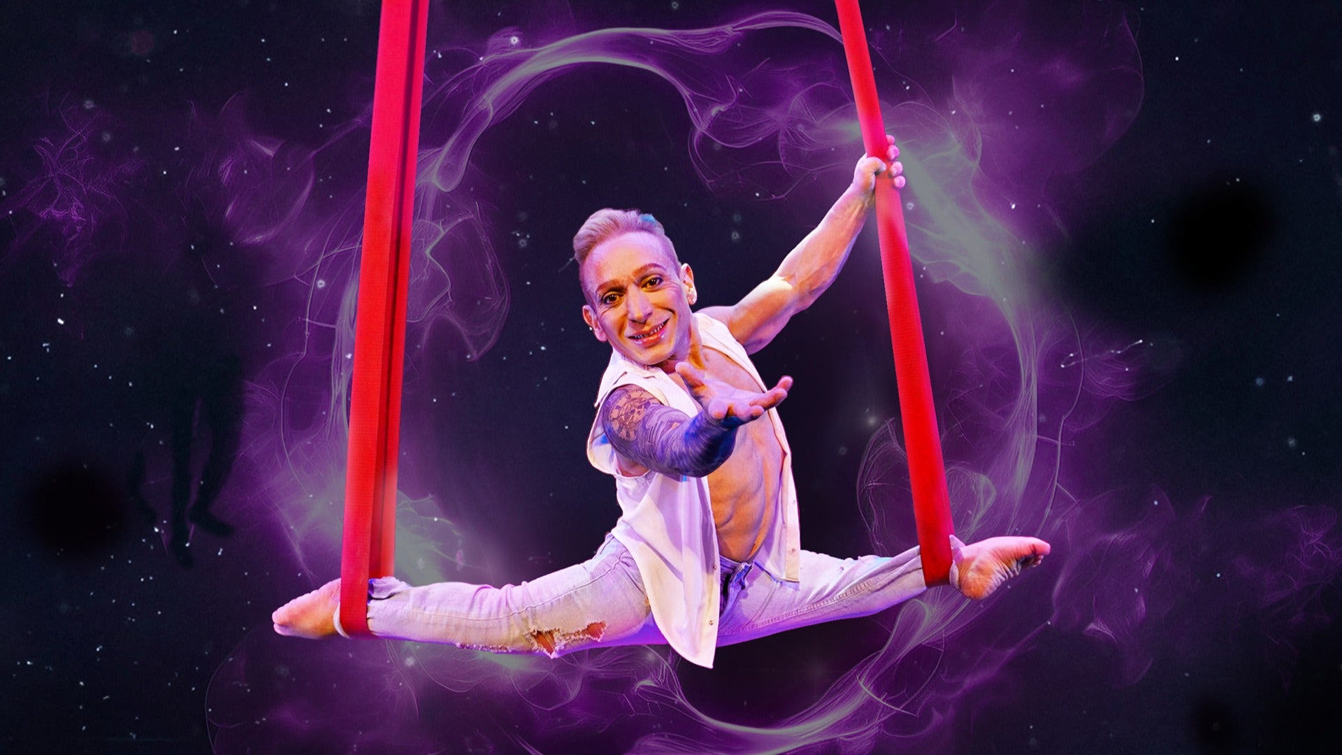 an acrobat midair balancing on cloth ropes