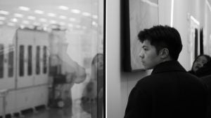 a man in an art gallery looking at paintings and displays