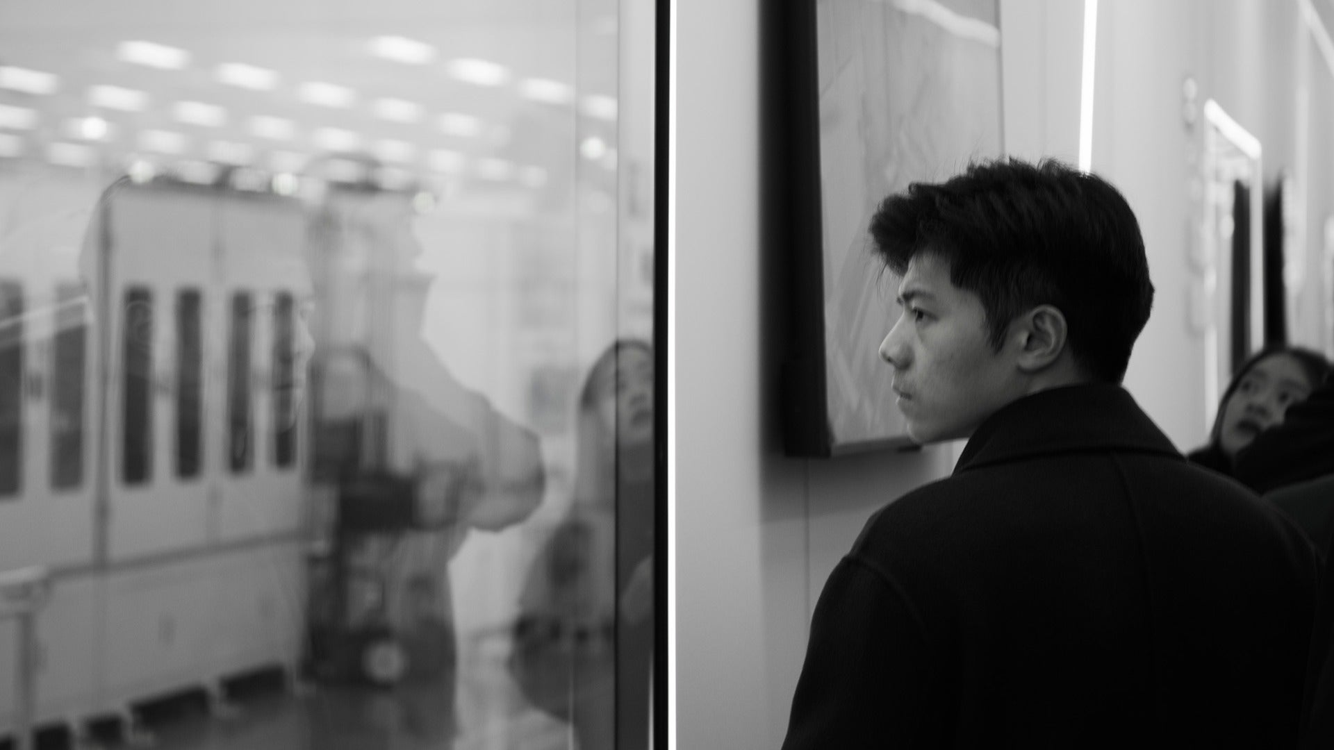 a man in an art gallery looking at paintings and displays