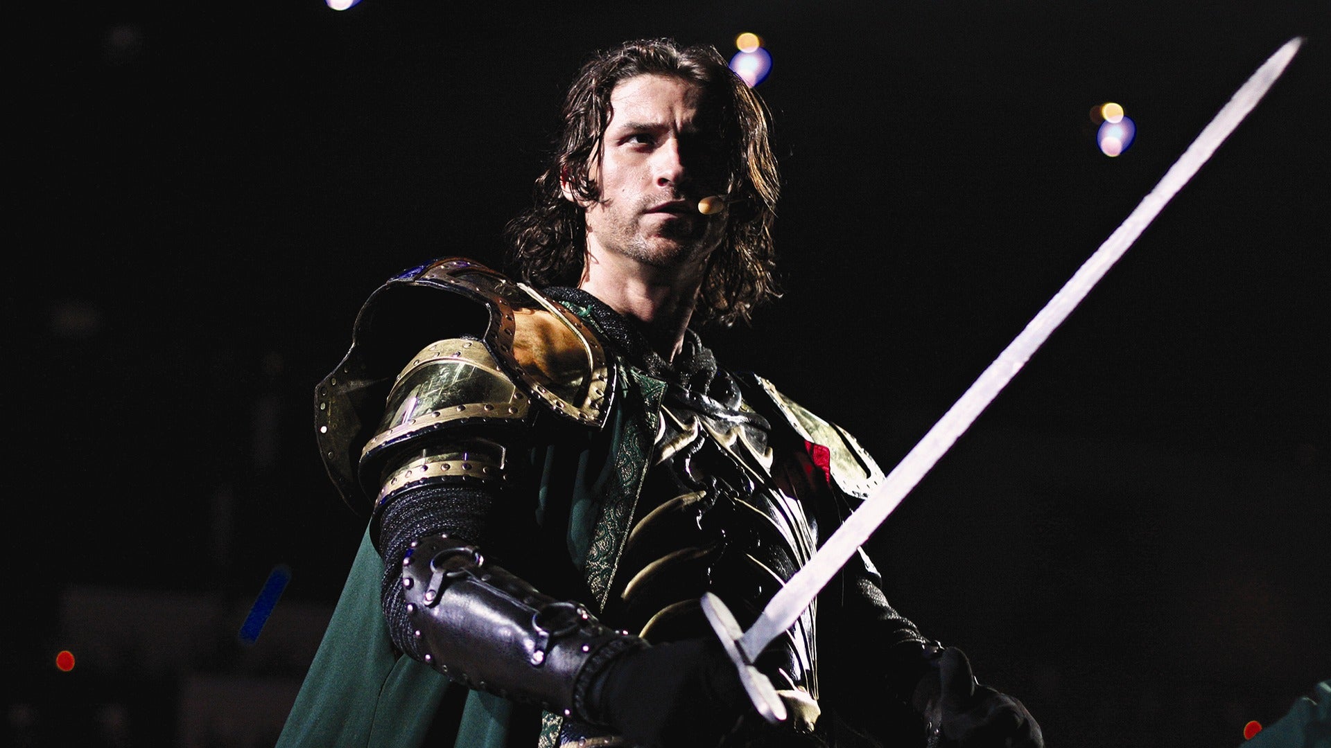 an actor dressed as a knight holding a sword