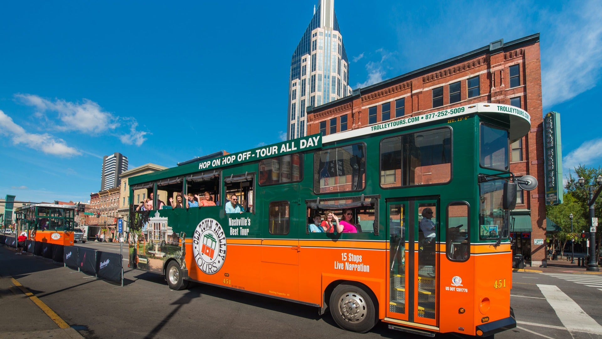 people aboard a trolley tour bus with building view at the back