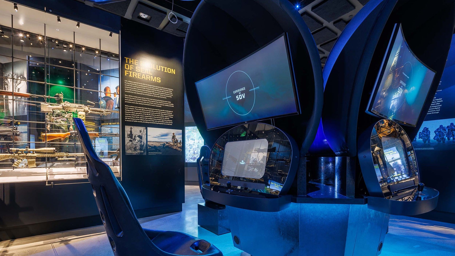 a control room with a chair and screens and exhibits on the side