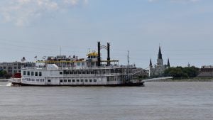 a cruise boat with passengers passing by the Mississippi river