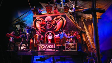 actors dressed as pirates aboard a ship, putting on a performance