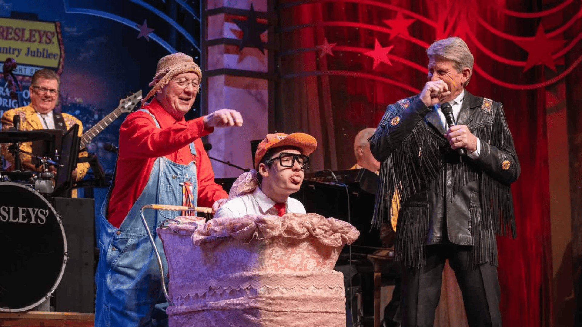 a group of performers on stage wearing costumes and holding props