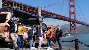 people taking a group photo in front of the golden gate bridge in san francisco