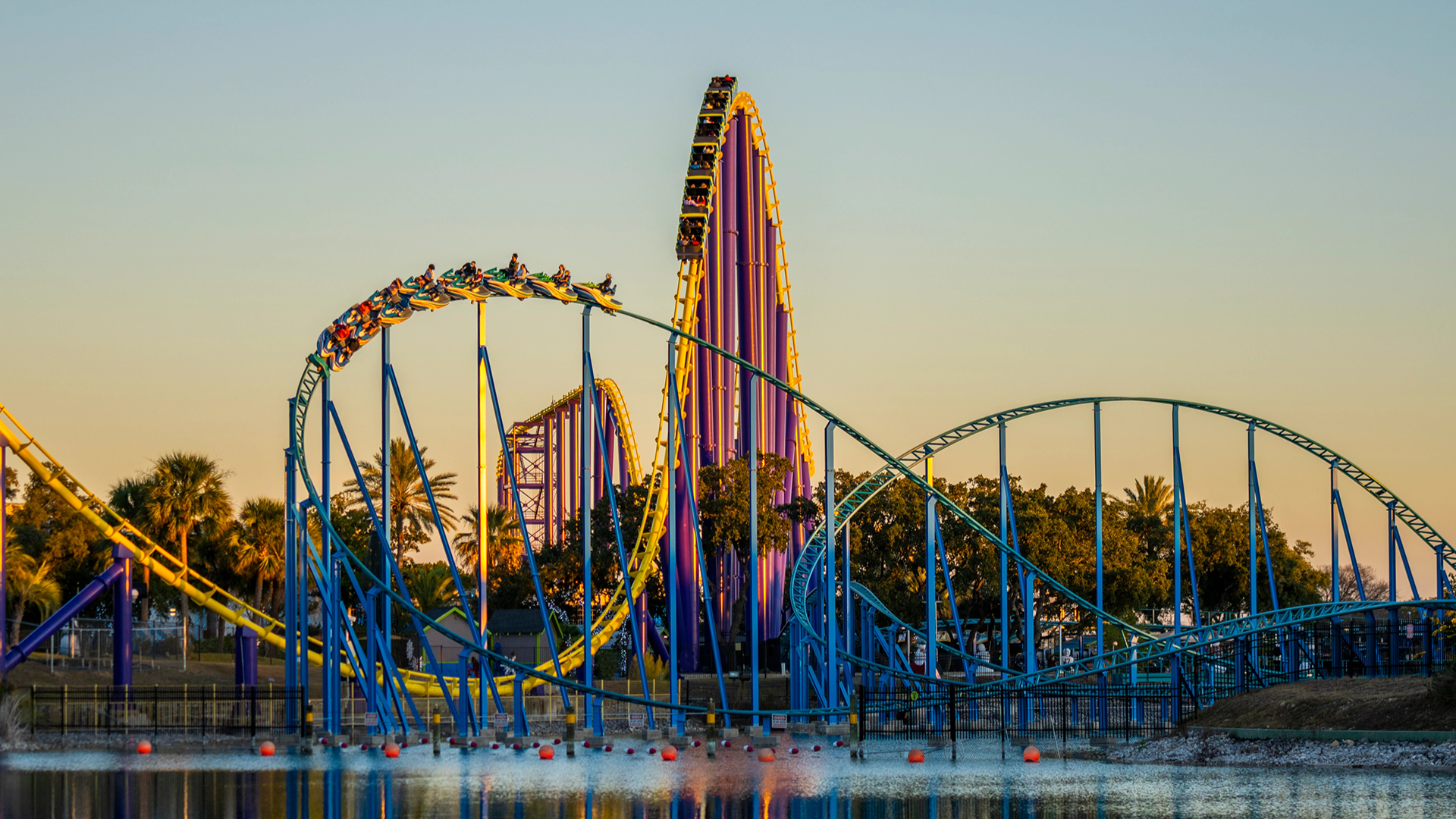 a roller coaster with a view of water features and people riding on it