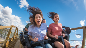 people having fun riding a roller coaster